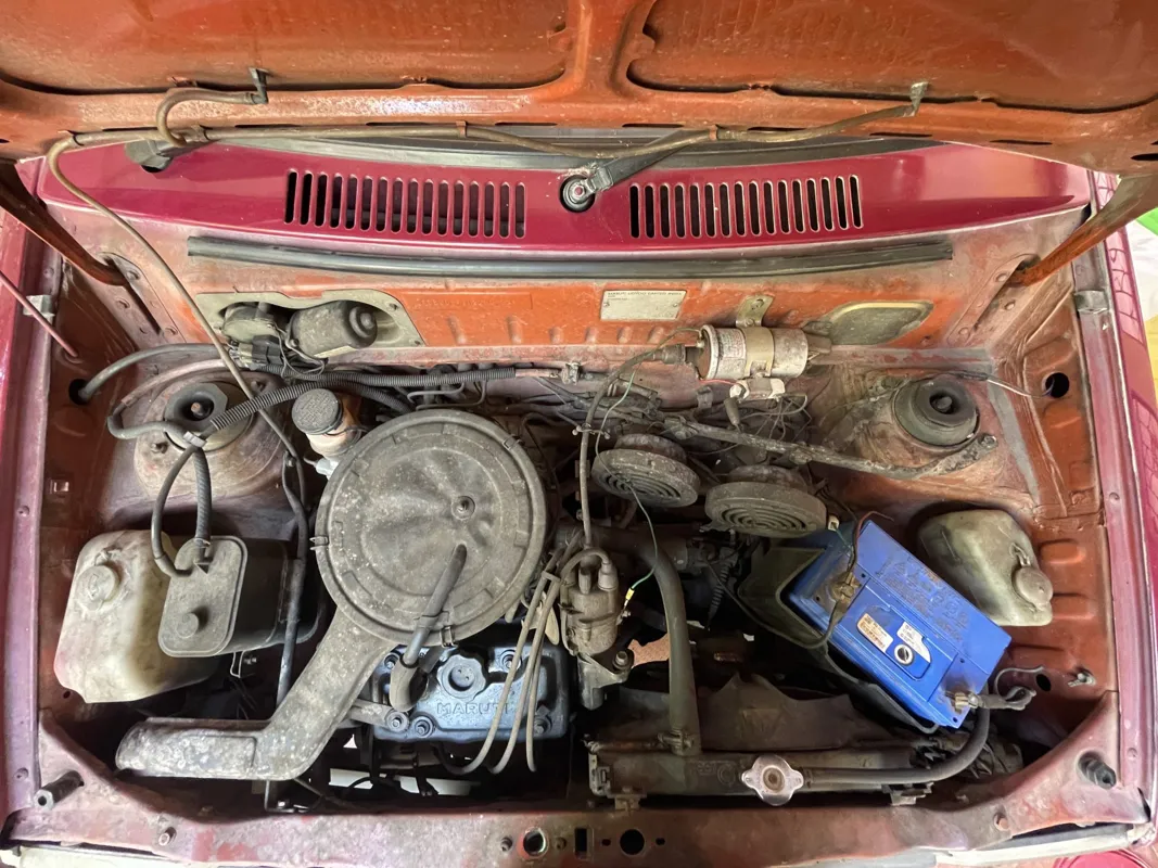 Dusty engine bay of an older car with the hood open