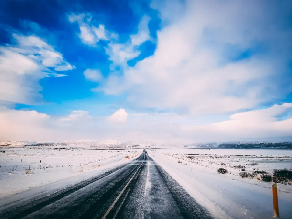 Empty two-lane road running through snowy open country